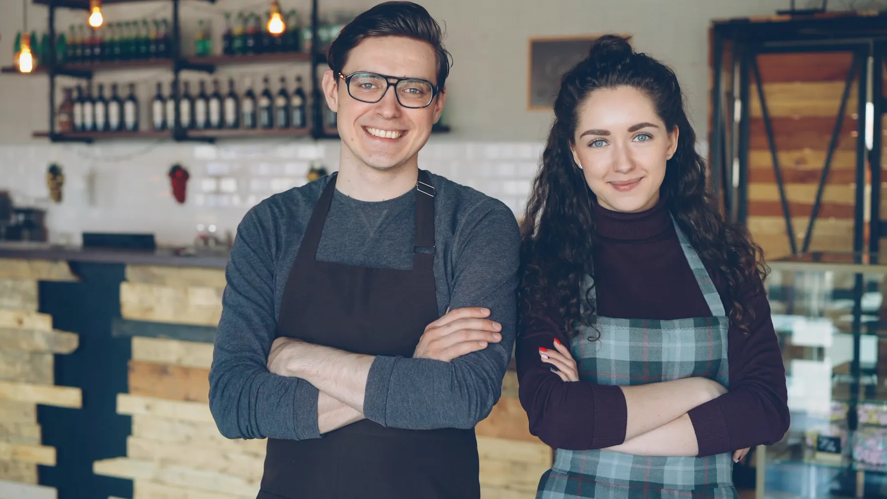 Zwei Café-Inhaber stehen stolz vor ihrer Theke
