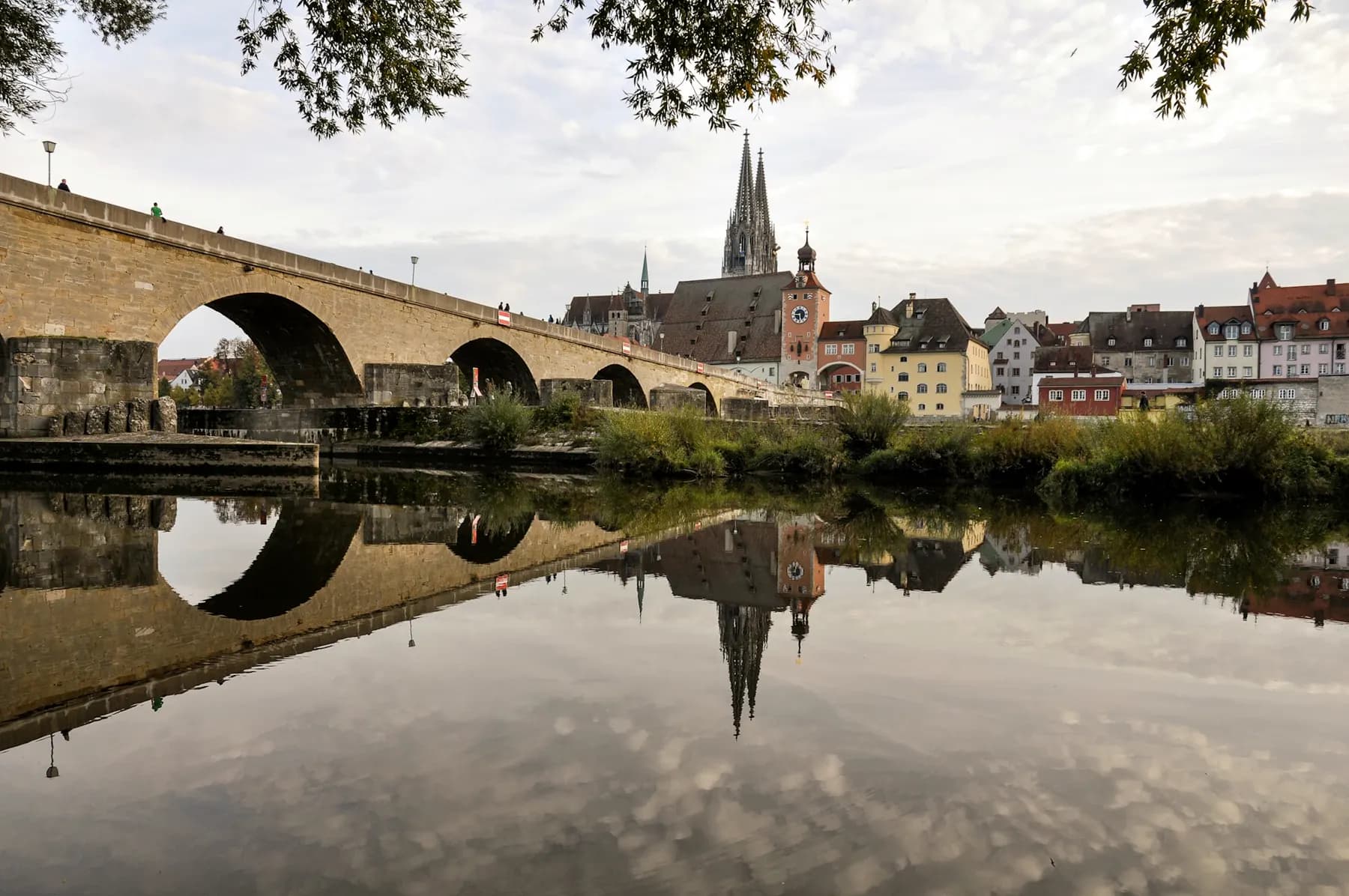 Steinerne Brücke in Regensburg mit Spiegelung in der Donau